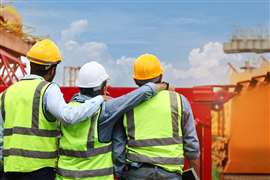 Construction workers look at site (Image: Adobe Stock)