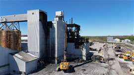 A high reach excavator tearing down a structure at the Massena East Paste Plant in New York