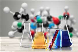 Chemicals in vials against a background of models of molecules.