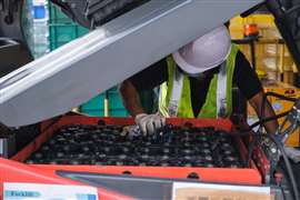 A technician inspects a forklift battery.